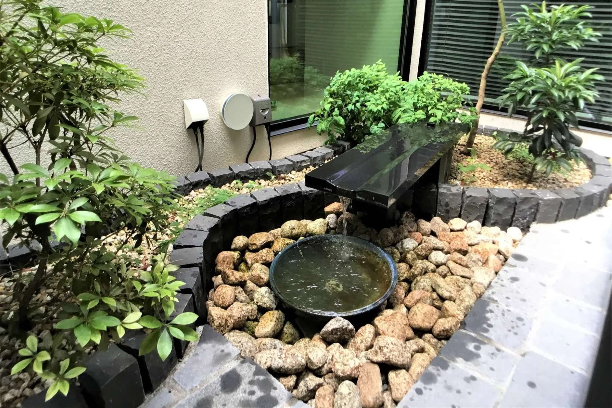 水盤から水鉢へ流れ落ちる水