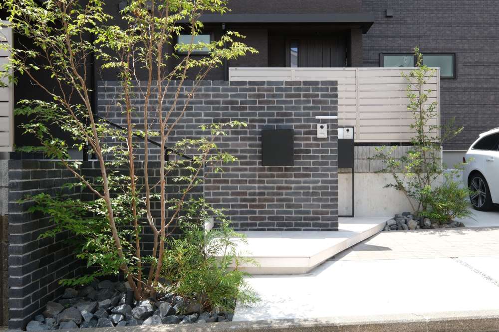 レンガ張り門柱と大判タイルアプローチのある二世帯住宅