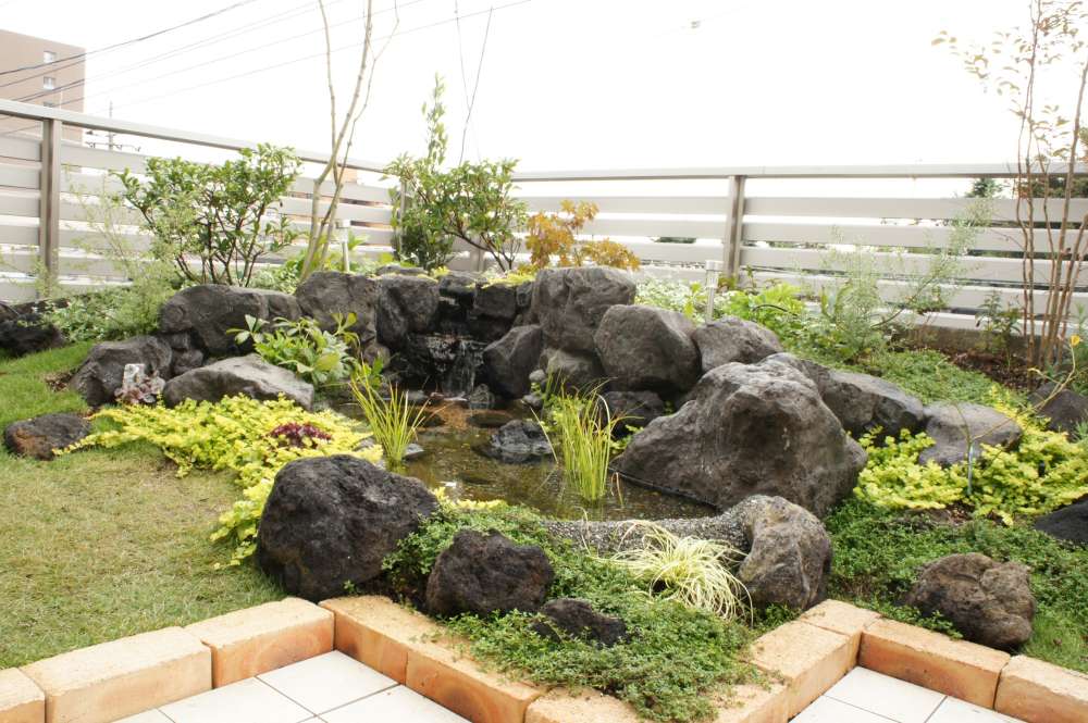 屋上を池と芝生とテラスで